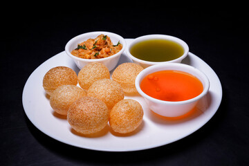 Delicious north and south indian street food pani puri gol gappa with tamarind water served in white plate and potato and chickpeas © Black Spade Design