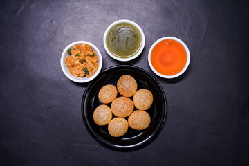 Delicious north and south indian street food pani puri gol gappa with tamarind water served in white plate and potato and chickpeas © Black Spade Design