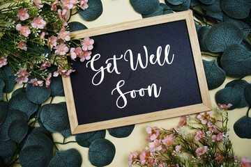 Get Well Soon text message with flowers bouquet decoration on yellow background