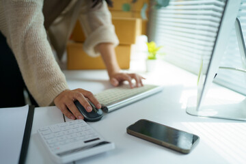 Online seller managing orders on computer in home office