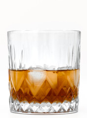 Whiskey with ice in a clear glass on a white background, luxury alcohol with ice