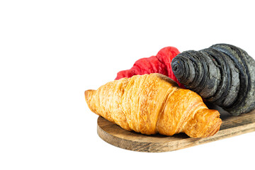 Red, black and classic croissants on a wooden board. Isolated on white.