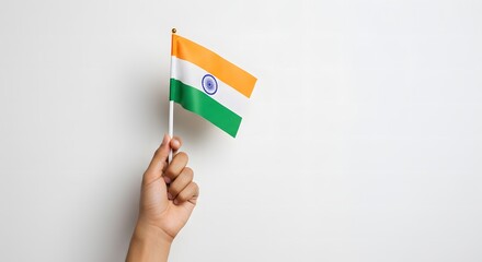 A hand proudly holds a small Indian flag against a plain white background.