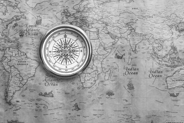 Classic round compass on background of old vintage map of world