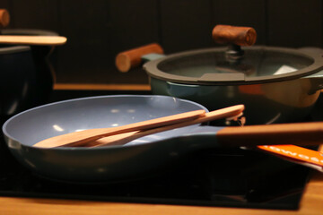 Modern Kitchen Cookware with Blue Frying Pan and Wooden Utensils