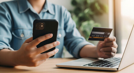 Person using a mobile device and a credit card for online transactions
