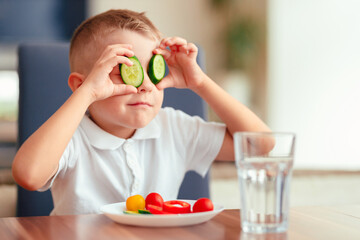Creative boy playing with vegetables while eating