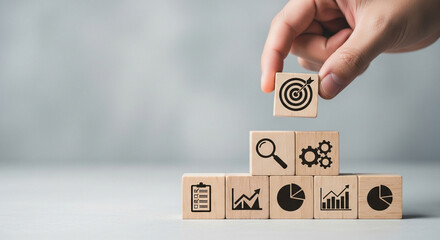 Building blocks with business icons stacked to represent progress and strategy