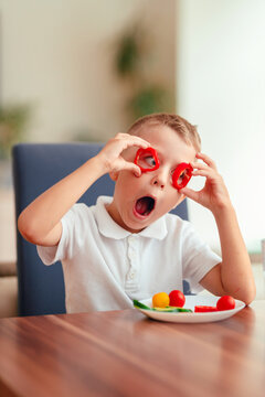 Creative boy playing with vegetables while eating