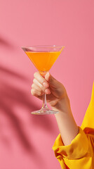 A woman's hand with a cocktail in her hand. A girl with a martini. Concept: summer party, end of summer, closing of summer season.