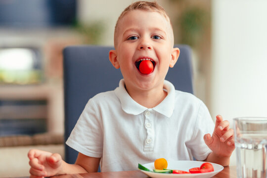 Creative boy playing with vegetables while eating