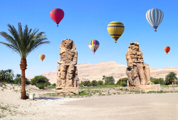 Tourist attraction balloon flight in Valley of Kings, Luxor, Egypt. Air balloons over the Colossi of Memnon in Theban Necropolis, Egypt. Topic of travel, trip abroad on vacation, cruises and tours