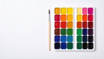 Naklejka premium Artistic Watercolor Paint Set: Vibrant colorful palette and brush on a clean white background with ample copy space.