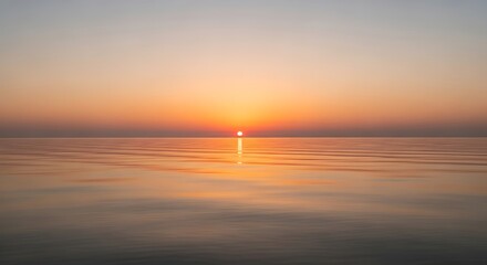 Obraz premium Peaceful seascape with the sun reflected in calm water at sunset or sunrise