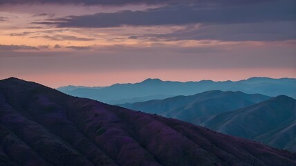 Dramatic layered mountain range at sunset with a beautiful gradient sky, peaceful landscape
