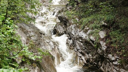 Rwący potok górski. Woda w potoku przemykająca między skałami.  © tomo81