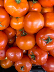 Ripe tomatoes stacked in a container, view from above