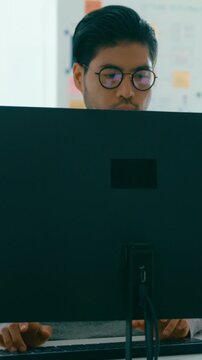 Vertical Screen : Young adult Asia male freelance eyeglasses typing write prompt AI bot app smart program nomad, video game, terminal with coding, user interface, big data center on desktop computer.