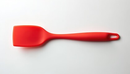Bright red silicone spatula, modern kitchen essential for cooking, baking. Versatile utensil features smooth handle with hanging loop for easy storage. Flexible blade perfect for scraping bowls,