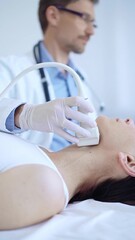 Obraz premium Doctor man wearing white protective gloves is using ultrasound machine to examine neck of female patient in hospital. Medicine, thyroid gland health
