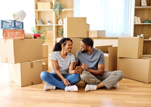 Portrait of a young couple unpacking, moving in and relocation to a new apartment, happy young couple  taking a selfie photo with a smartphone, family new beginning sitting on the floor