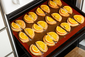 Closeup homemade cookies with slices of orange baked in a home oven. Shallow focus.
