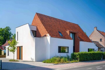Modern architecture showcases a unique blend of materials and shapes in a suburban neighborhood under clear blue skies during the daytime