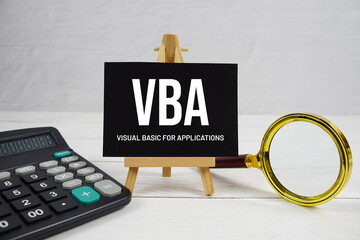 VBA abbreviation of Visual Basic for Applications text with magnifying glass and calculator on...