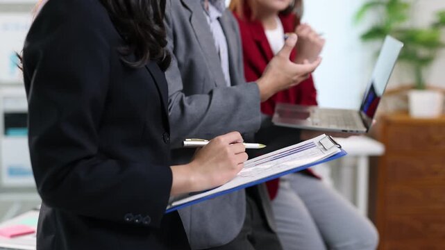 Professional business team analyzing data on laptop, discussing strategic project details during collaborative office meeting, sharing insights and working toward common goals.