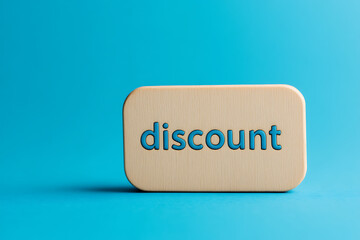 Discount offer. Wooden block with blue text on a blue background, symbolizing sales and price reduction.