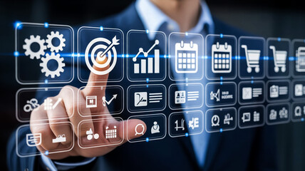 Businessman interacting with futuristic digital interface displaying business icons and data analytics