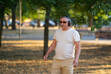 Senior man in headphones outdoors