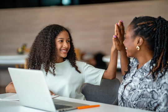 African school teacher is teaching and guiding young student and having high five in the class using information from experience and internet for academic literacy study and education usage