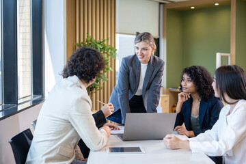 Caucasian woman sale manager is showing annual report chart to her colleague in executive meeting for next year plan with market share increase for global business and investment