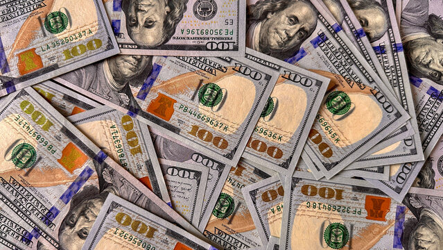 Top view of multiple folded one hundred dollar bills arranged in a pile. A large stack of US currency banknotes on a flat surface, creating a rich money background. - Powered by Adobe