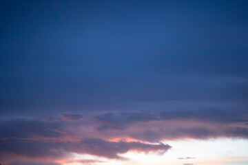 A beautiful evening sky painted in soft pastel colors of pink, purple, and orange. Wispy clouds stretch across the horizon, reflecting the warm hues of the setting sun. This peaceful and dreamy sky ca