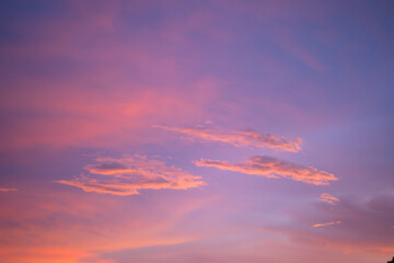 A beautiful evening sky painted in soft pastel colors of pink, purple, and orange. Wispy clouds stretch across the horizon, reflecting the warm hues of the setting sun. This peaceful and dreamy sky ca