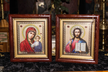 Obraz premium Religious icons of the Virgin Mary and Jesus displayed on an altar in a serene setting during evening light