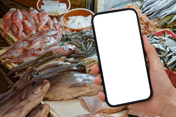 A cell phone with a transparent background photographs the offerings at a fish market. PNG