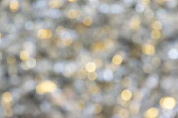 Soft, shimmering bokeh effect creating a warm atmosphere with golden and silver hues for festive decor