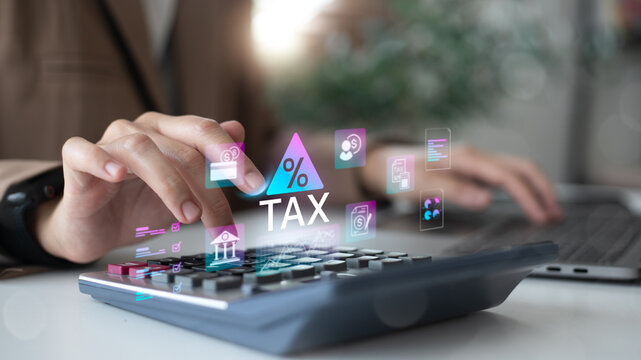 Businesswoman using calculator and laptop with virtual tax icon. Digital finance, fintech, and online tax filing concept. Professional female accountant. - Powered by Adobe