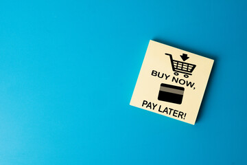 Top view of a Buy Now Pay Later (BNPL) service card on a blue background. Concept of modern fintech, consumerism, debt, credit risk, and installment payments for online retail shopping.