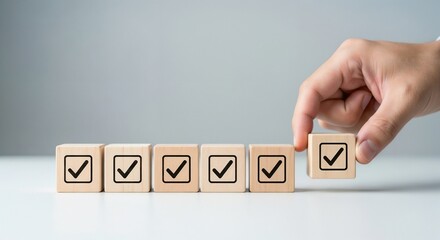 A hand placing a wooden block with a checkmark to complete a row, symbolizing the completion of tasks or meeting quality standards.
Image 9