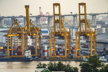 Background for cranes and industrial cargo ships in port at twilight.