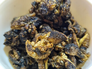 Flourless snail chips have a savory, delicious and crunchy taste. Presented with a white bowl with a natural blur background.