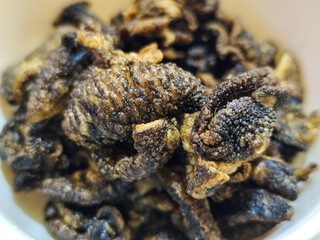 Flourless snail chips have a savory, delicious and crunchy taste. Presented with a white bowl with a natural blur background.