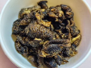 Flourless snail chips have a savory, delicious and crunchy taste. Presented with a white bowl with a natural blur background.