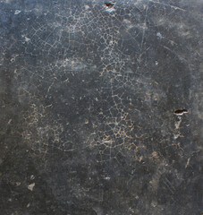Cracked Dark Surface. Close-up of a dark cracked surface with fine web-like lines, evoking an aged or weathered appearance.