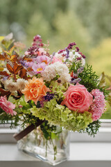 A delightful summer bouquet with English roses, lavender, hydrangeas, anemones and other flowers. a perfect bouquet with roses in a vase on the window.