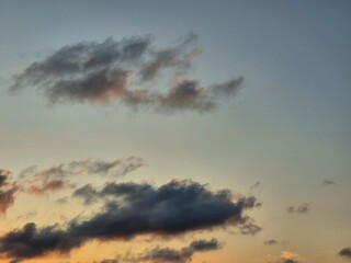 Colorful sunset sky with scattered dark clouds and warm orange evening glow